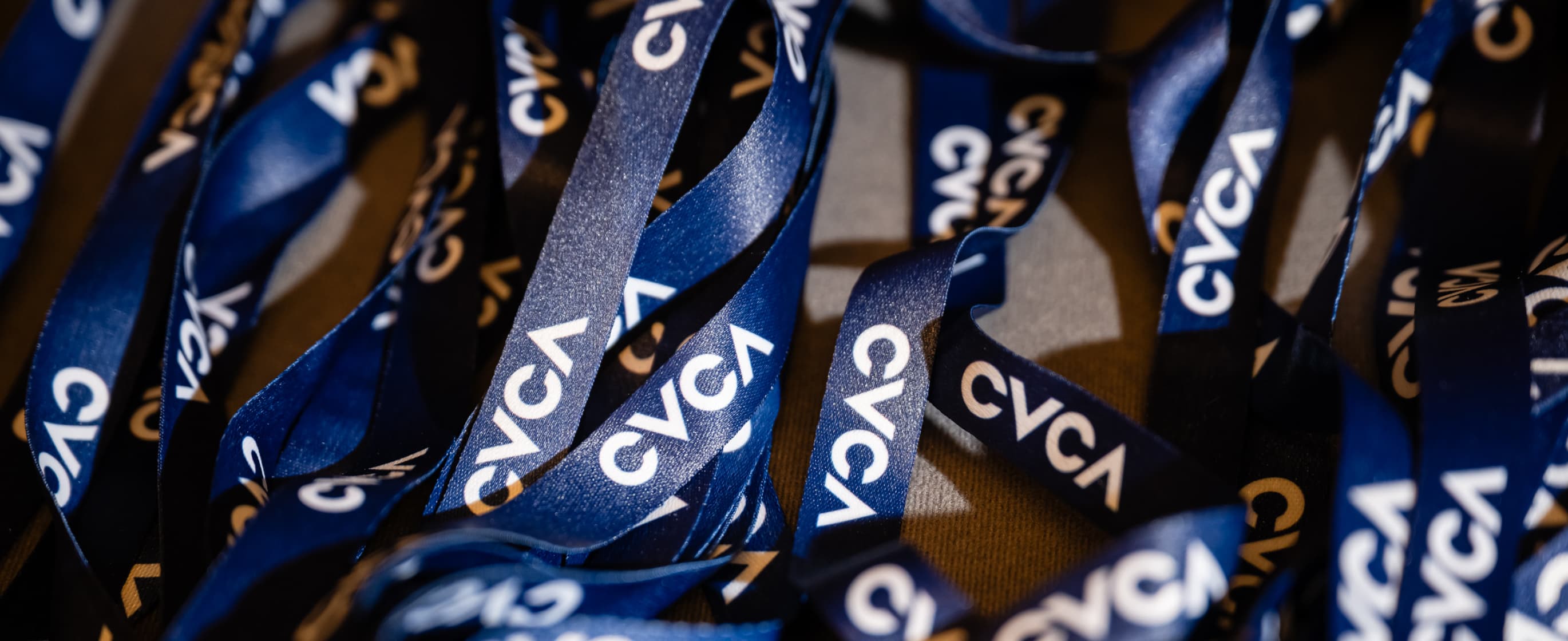 A stack of blue lanyards with the word CVCA on them